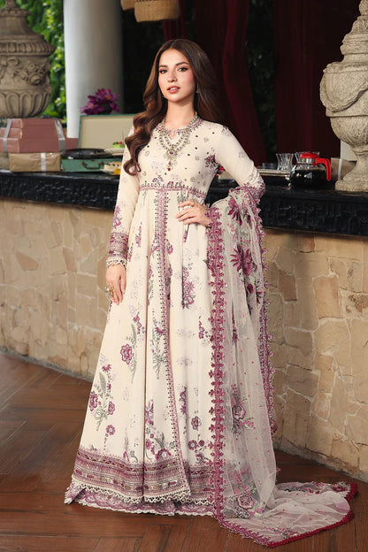Woman in a floral dress standing in an outdoor setting with stone walls and decorative elements.