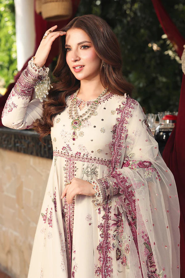 Woman in a traditional embroidered outfit with jewelry, standing outdoors.