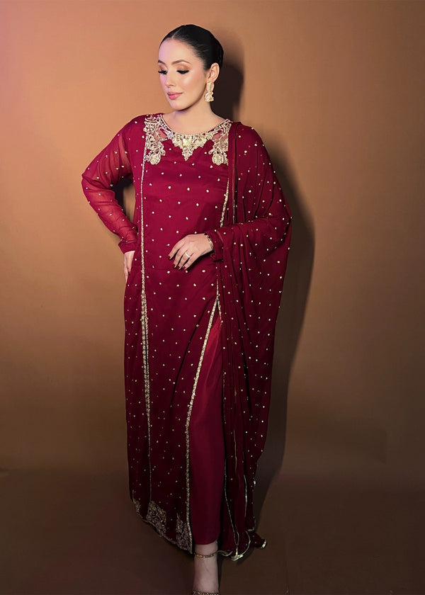  Agha Jaan deep red Pakistani designer dress with gold embroidery and sequin detail.  