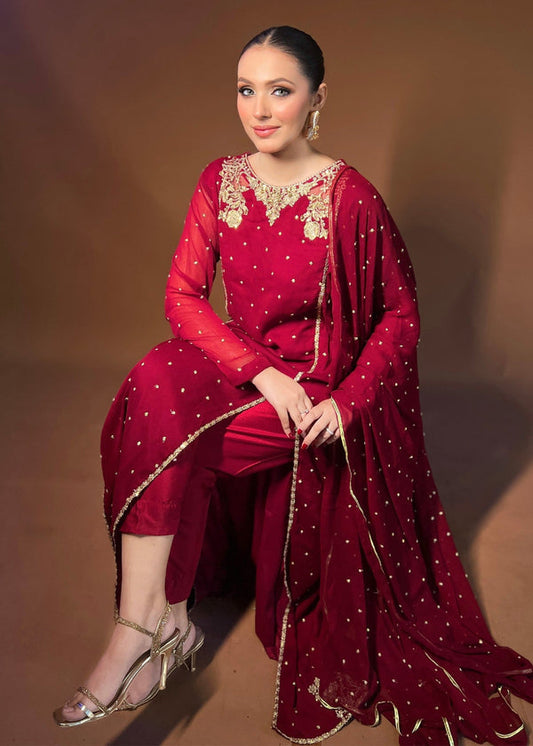  Agha Jaan deep red Pakistani designer dress with gold embroidery and sequin detail.  