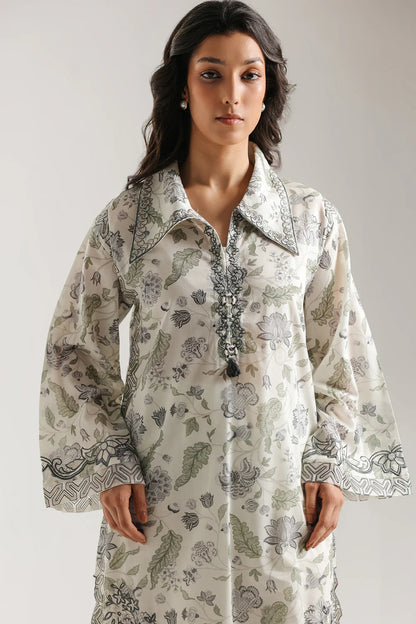 Woman wearing a floral patterned dress against a plain background