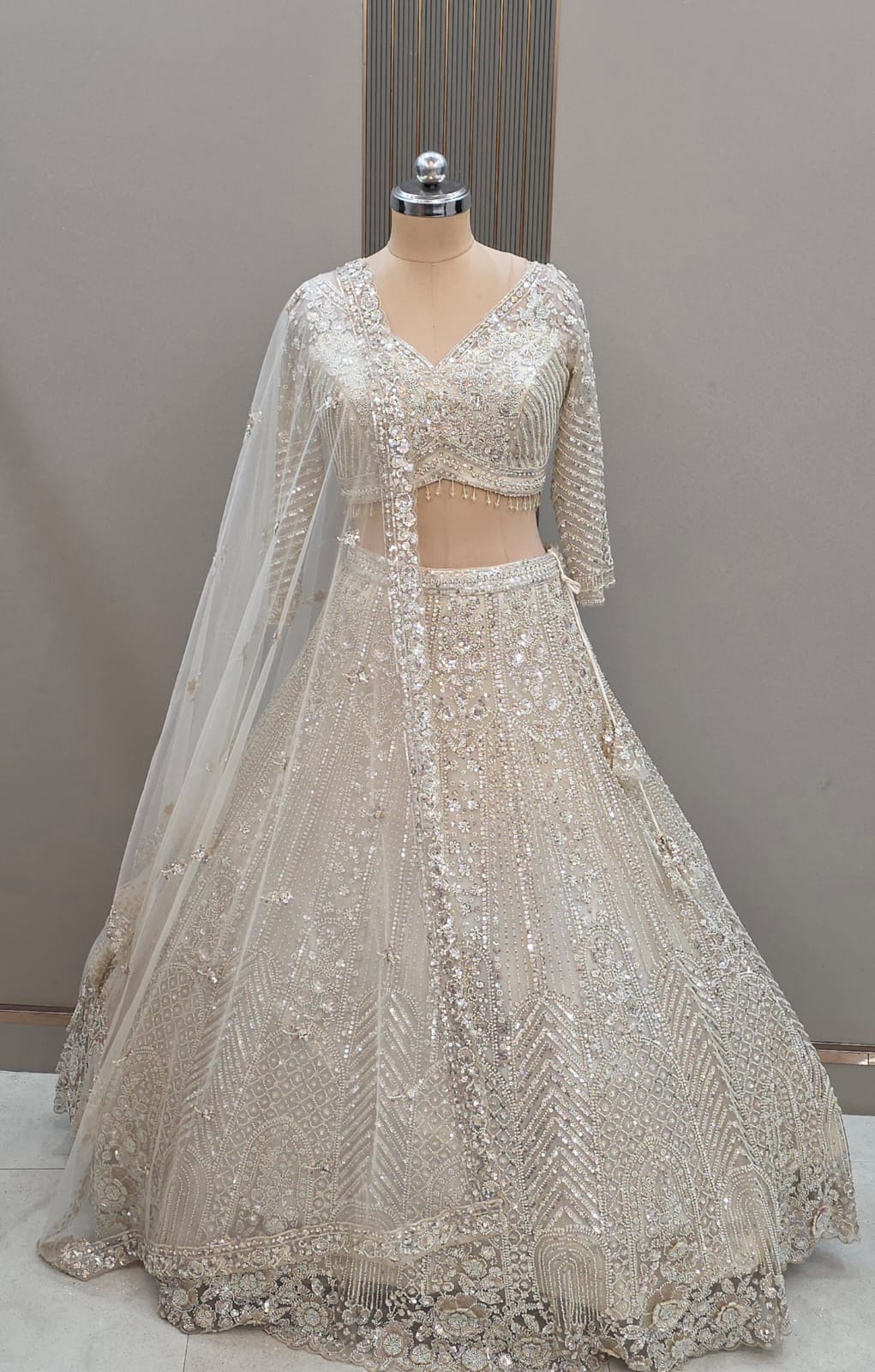 Ivory silver luxury designer net lehenga with heavy sequence and stone embellishments by Tajori