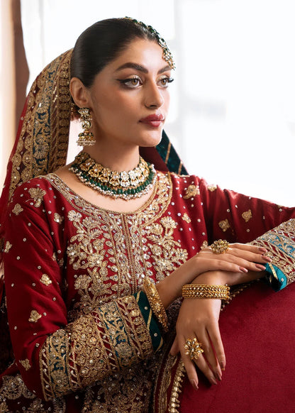 Woman in traditional embroidered outfit with jewelry against a white background