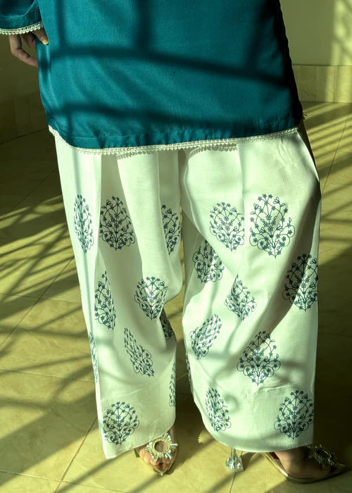 Detail of white farsi shalwar with floral print, paired with teal kurta by Tehzeeb Libas