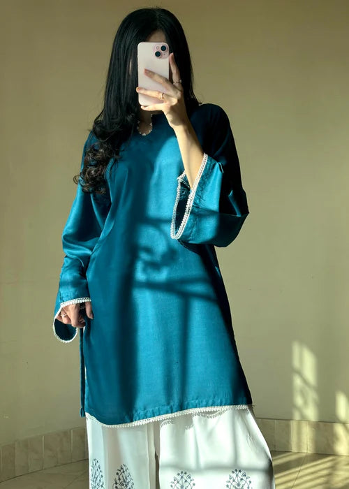 Model wearing Tehzeeb Libas teal silk kurta with white printed farsi shalwar, elegant daily wear
