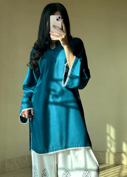 Model wearing Tehzeeb Libas teal silk kurta with white printed farsi shalwar, elegant daily wear