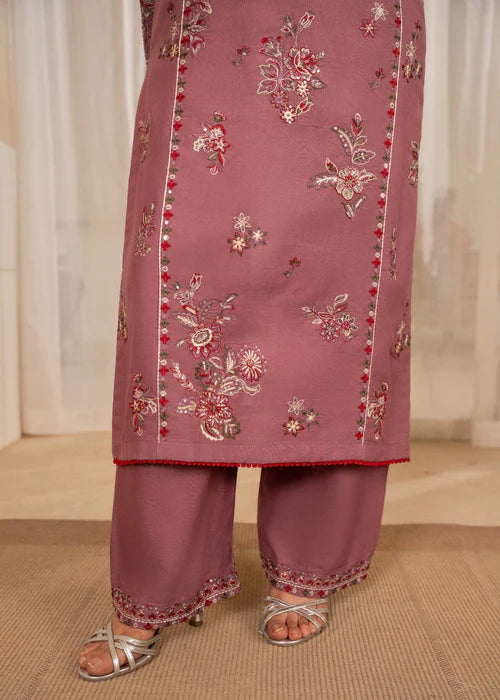 Pink embroidered traditional outfit with floral patterns on a neutral background