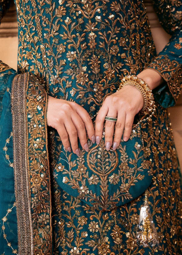 Close-up of a person wearing a teal and gold embroidered traditional outfit with jewelry.